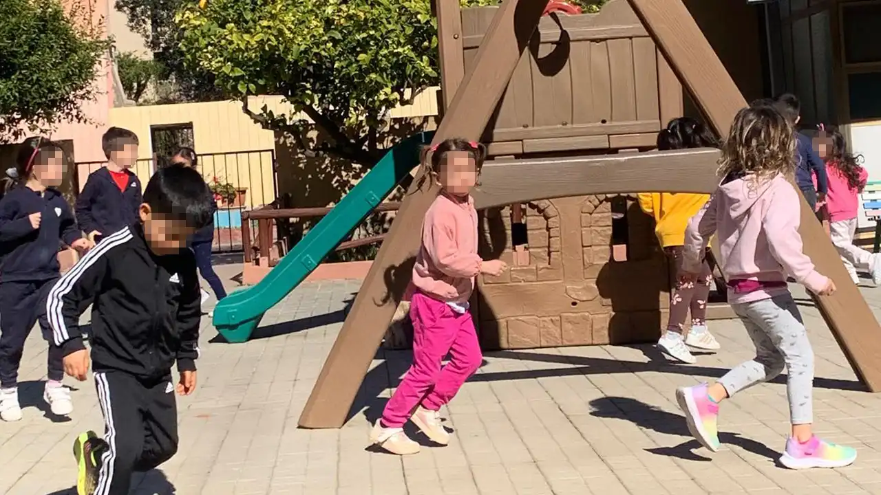 Bambini giocano e corrono nel giardino della Scuola dell'Infanzia Provvidenza Sacro Cuore.