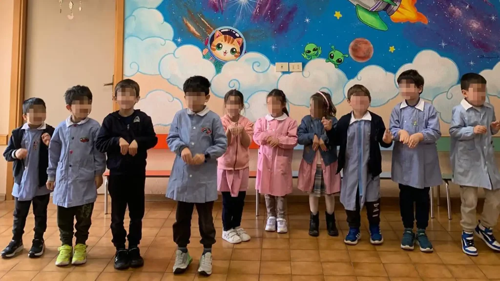 Gruppo di bambini partecipa a un'attività educativa negli spazi interni della Scuola dell'Infanzia Provvidenza Sacro Cuore.