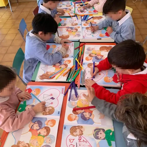 Bambini realizzano disegni e attività creative durante un laboratorio nella scuola dell'infanzia.