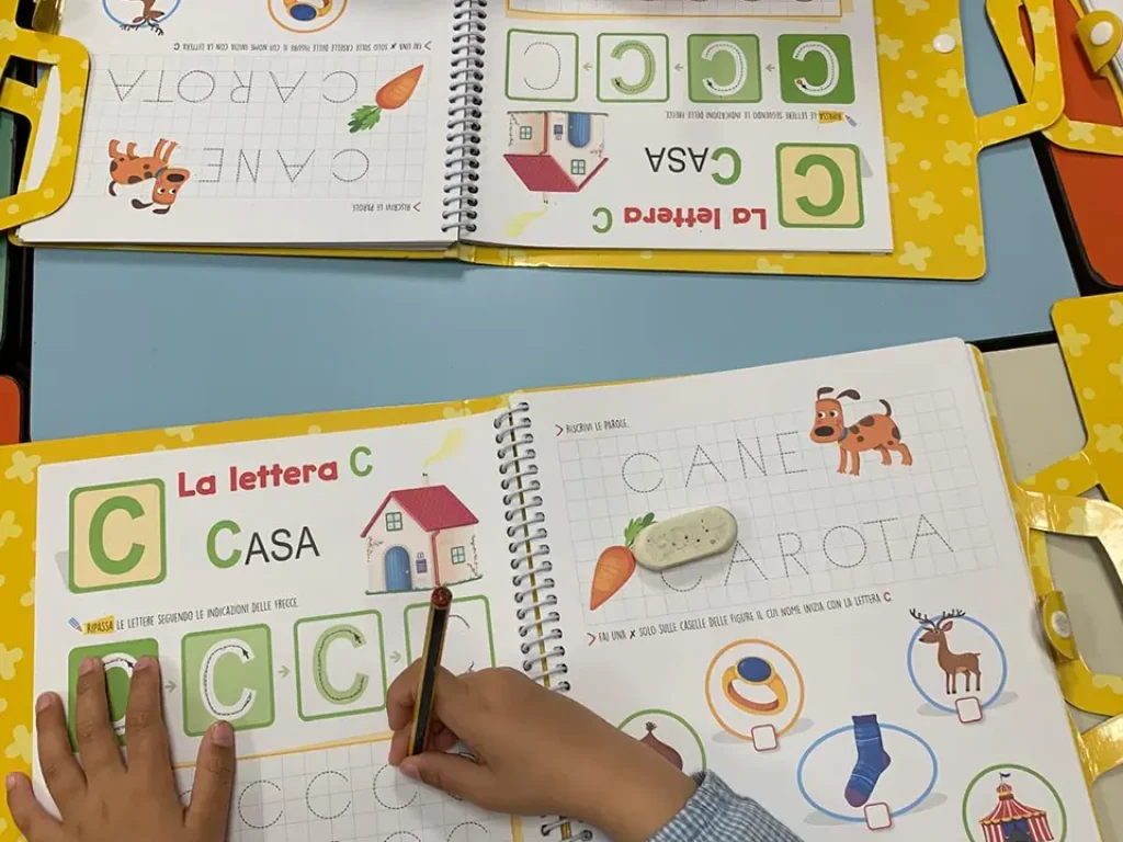 bambini lavorano al pregrafismo sul libro di testo