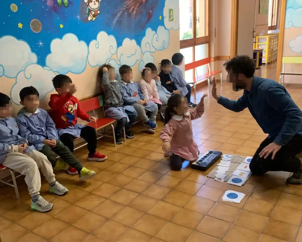 Insegnante conduce un laboratorio musicale con bambini nella scuola dell'infanzia.